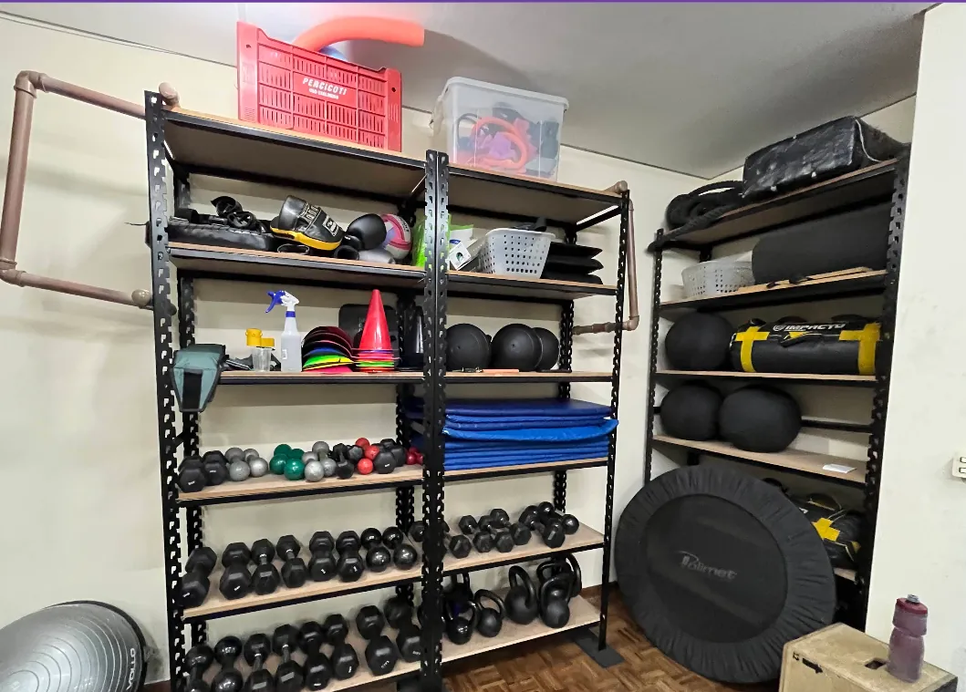Prateleiras com halteres, kettlebells, medicine balls e acessórios de treino